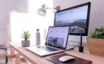 MacBook Pro on table beside white iMac and Magic Mouse